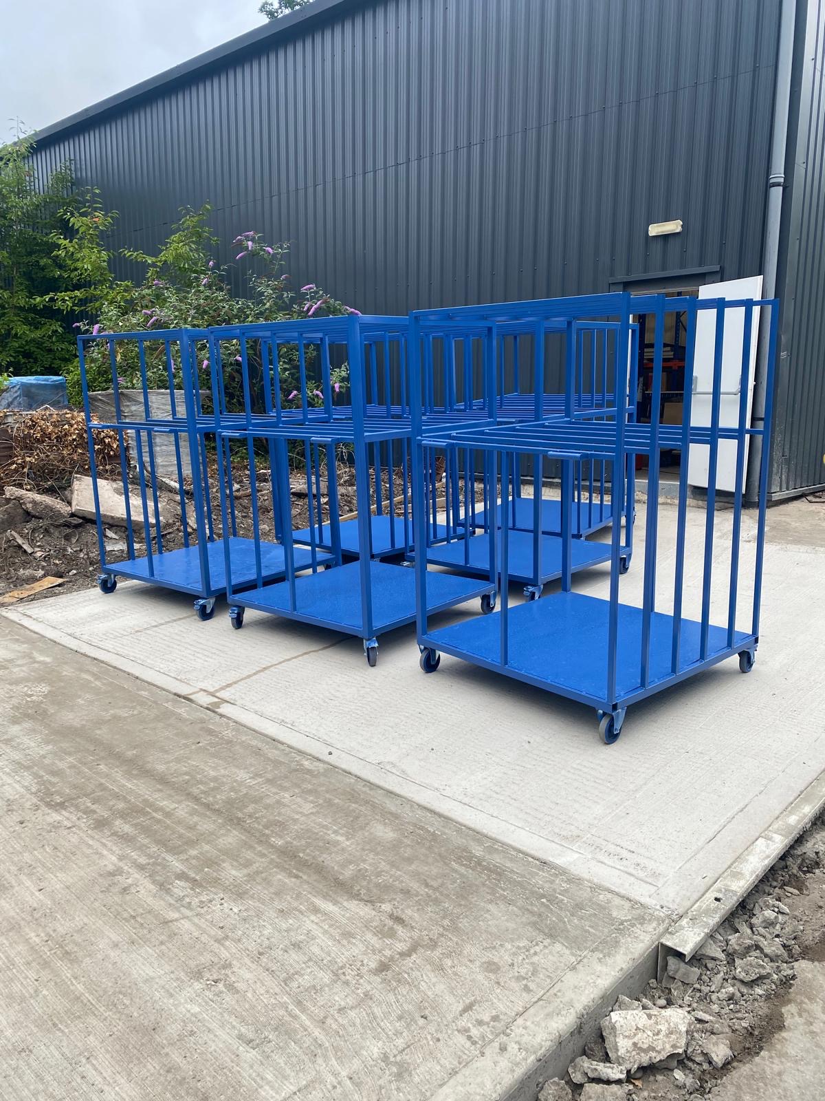 Blue steel trolleys with cages outdoors